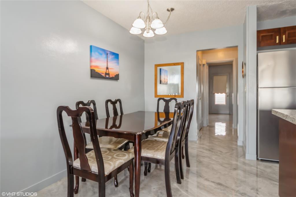 800 Southwest 11th Avenue, Unit 17 Hallandale Beach, FL 33009 - Photo 6 of 18 a view of a dining room with furniture and chandelier