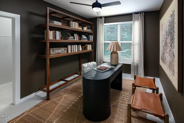 a view of a workspace with furniture and a window