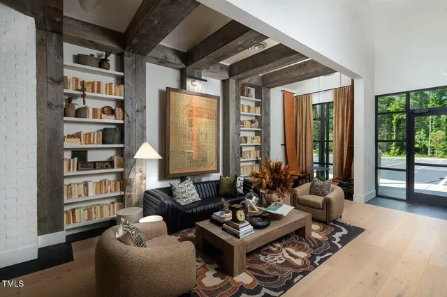 a living room with furniture a bookshelf and a window