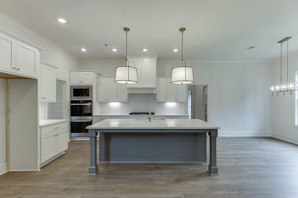 314 Level Creek Road Sugar Hill, GA 30518 - Photo 16 of 62 a view of a kitchen with kitchen island a sink stainless steel appliances and a chandelier