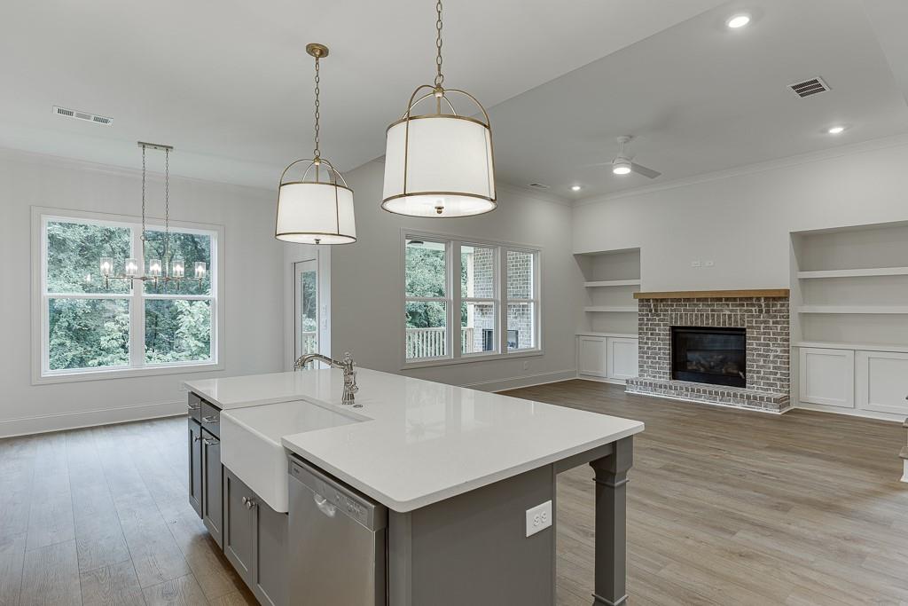 314 Level Creek Road Sugar Hill, GA 30518 - Photo 19 of 62 a kitchen with a sink chandelier and a fireplace