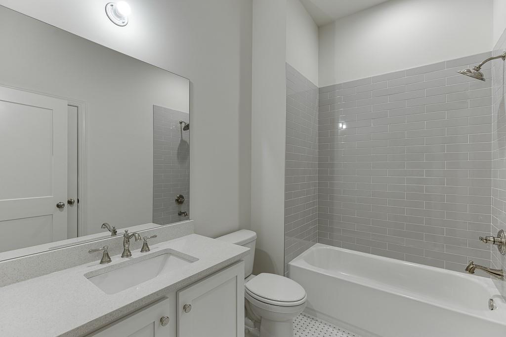 314 Level Creek Road Sugar Hill, GA 30518 - Photo 27 of 62 a bathroom with a granite countertop bathtub shower sink mirror vanity and toilet