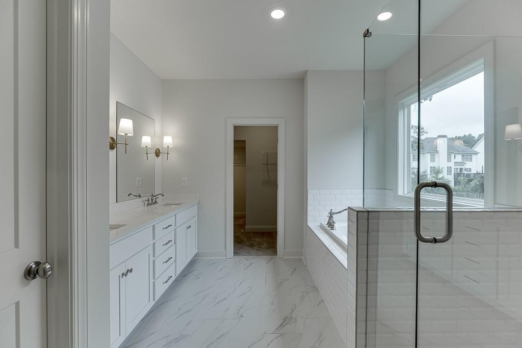 314 Level Creek Road Sugar Hill, GA 30518 - Photo 43 of 62 a bathroom with a double vanity sink a mirror and a bathtub