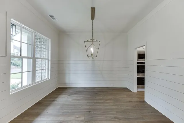a view of empty room with wooden floor and windows