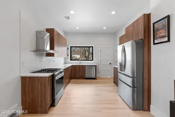 a kitchen with granite countertop wooden cabinets and stainless steel appliances