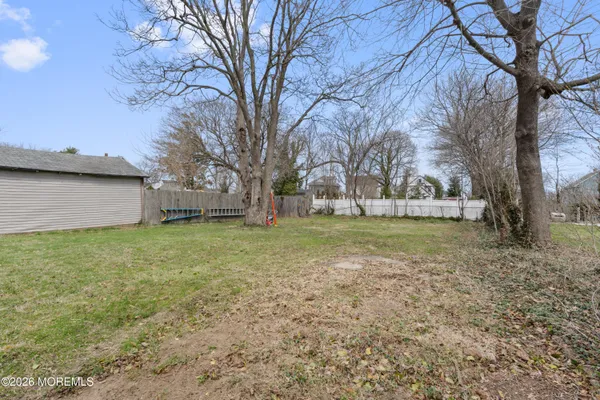 a view of a house with a yard and large tree