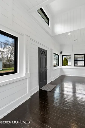 a view of an entryway with wooden floor and door