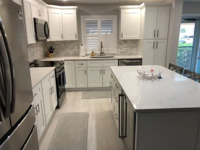 a living room with a flat screen tv on dresser and a table