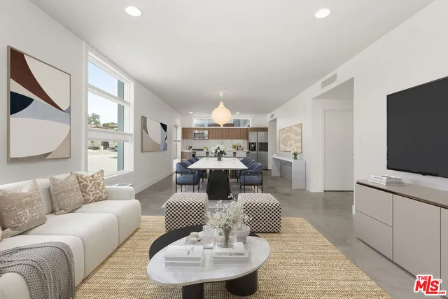 a living room with furniture kitchen view and a large window