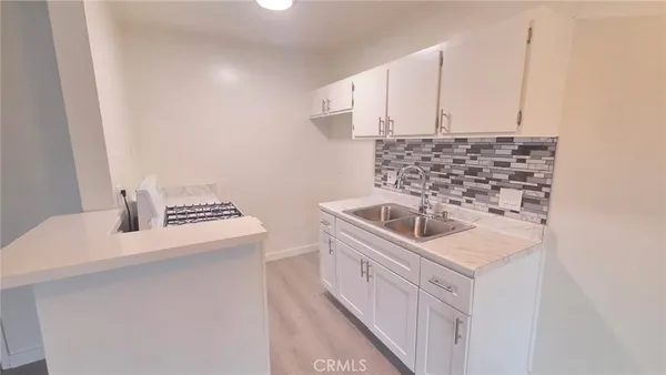 a kitchen with white cabinets and appliances