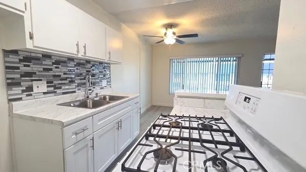 a view of kitchen with granite countertop cabinets and white appliances
