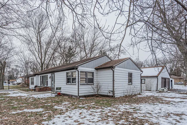 a view of a house with a yard covered in snow