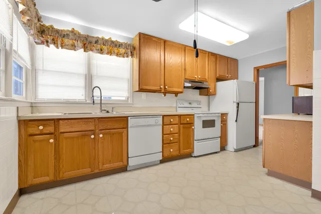 a kitchen with stainless steel appliances granite countertop a sink a stove and refrigerator