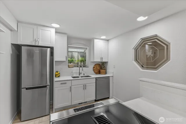 a kitchen with stainless steel appliances a refrigerator sink and cabinets