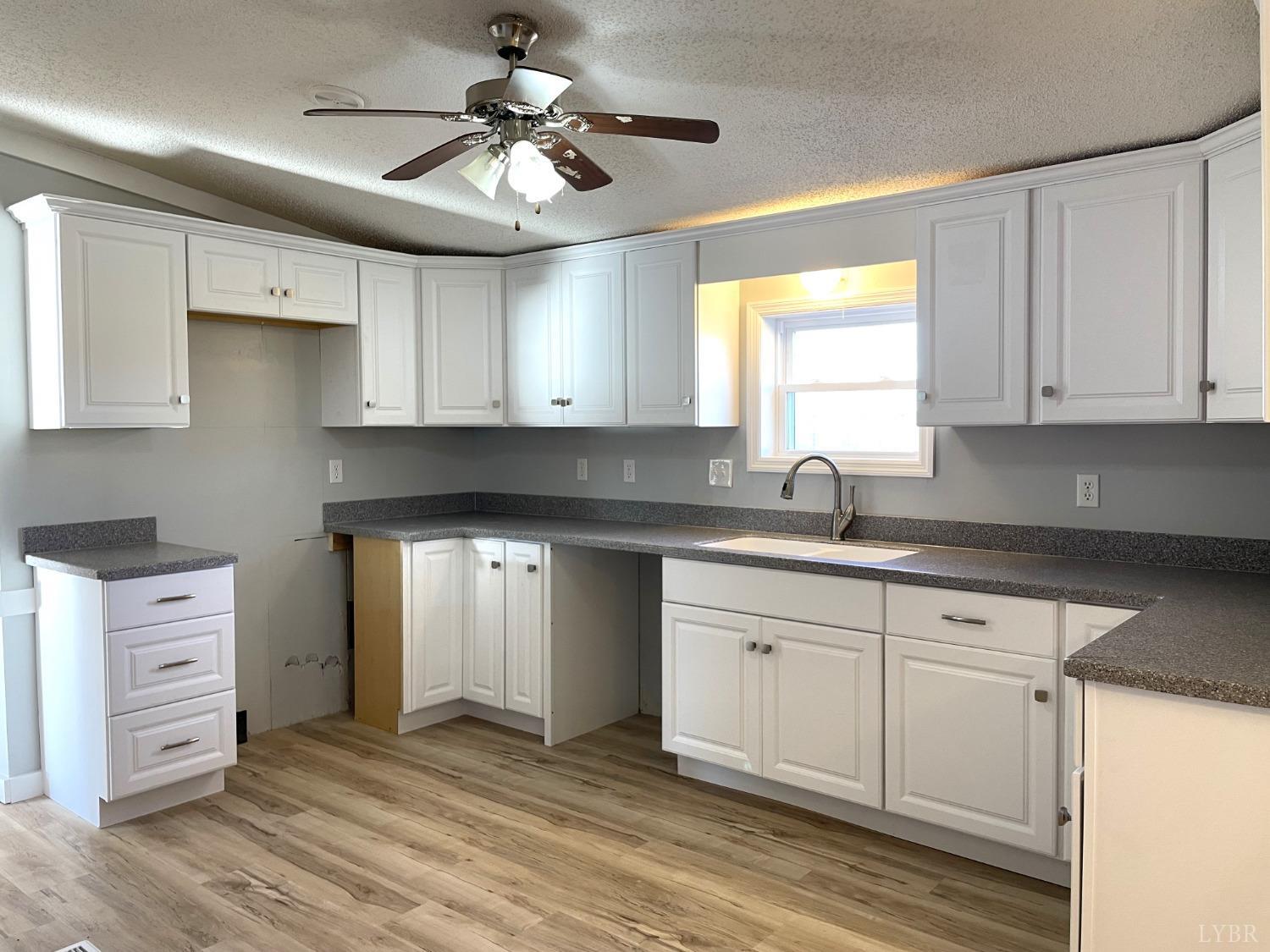 232 Camp Branch Road Gretna, VA 24557 - Photo 14 of 47 a kitchen with white cabinets and sink