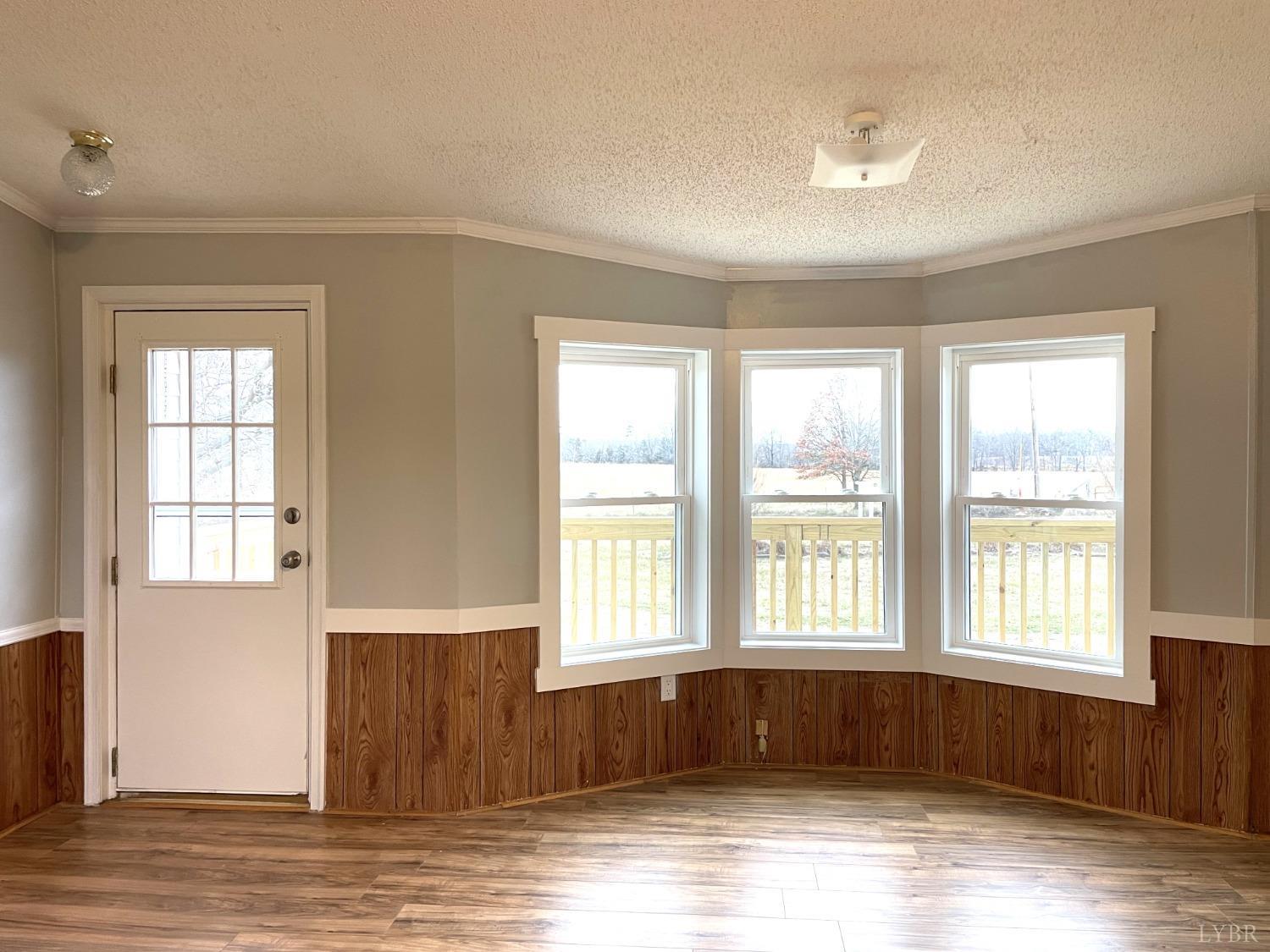 232 Camp Branch Road Gretna, VA 24557 - Photo 5 of 47 a view of an empty room with wooden floor and a window