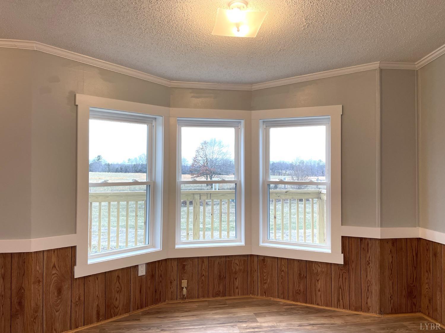 232 Camp Branch Road Gretna, VA 24557 - Photo 6 of 47 a view of an empty room with wooden floor and a window