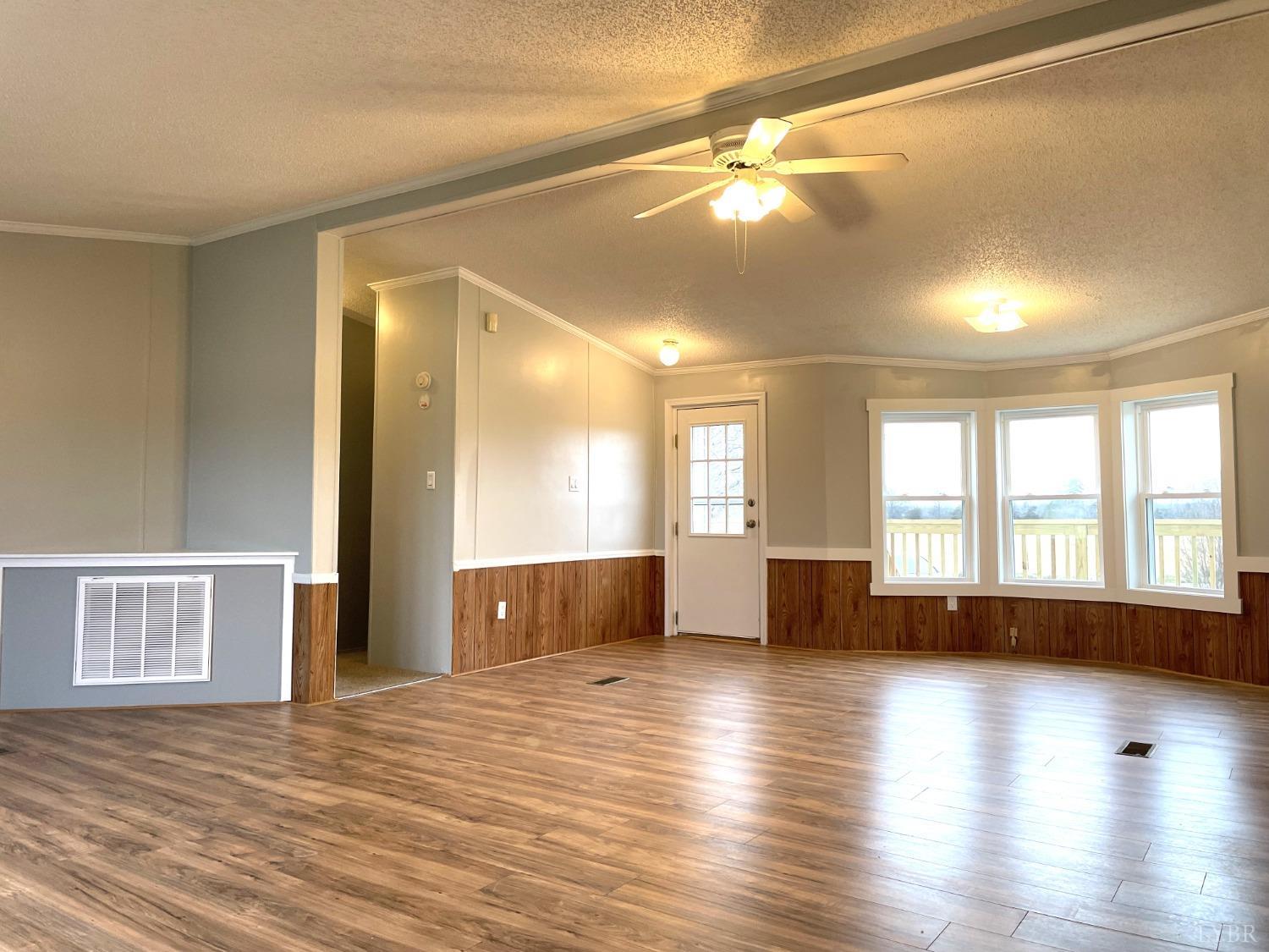 232 Camp Branch Road Gretna, VA 24557 - Photo 9 of 47 a view of empty room with wooden floor and fan