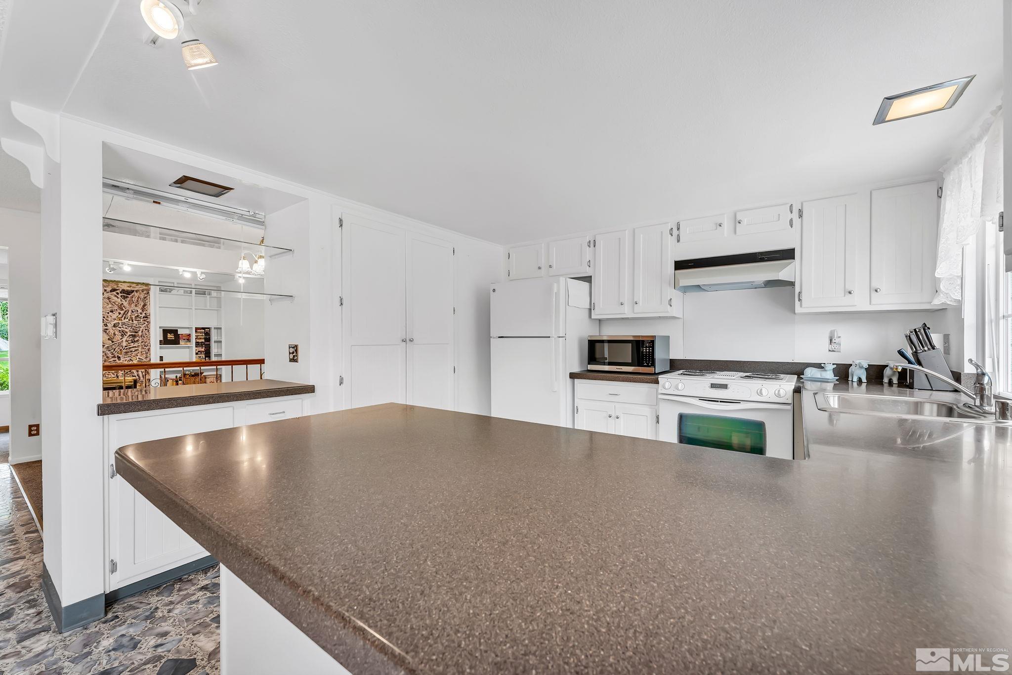 1407 Foster Drive Reno, NV 89509 - Photo 14 of 34 a kitchen with stainless steel appliances granite countertop a refrigerator a stove and a sink with wooden floor
