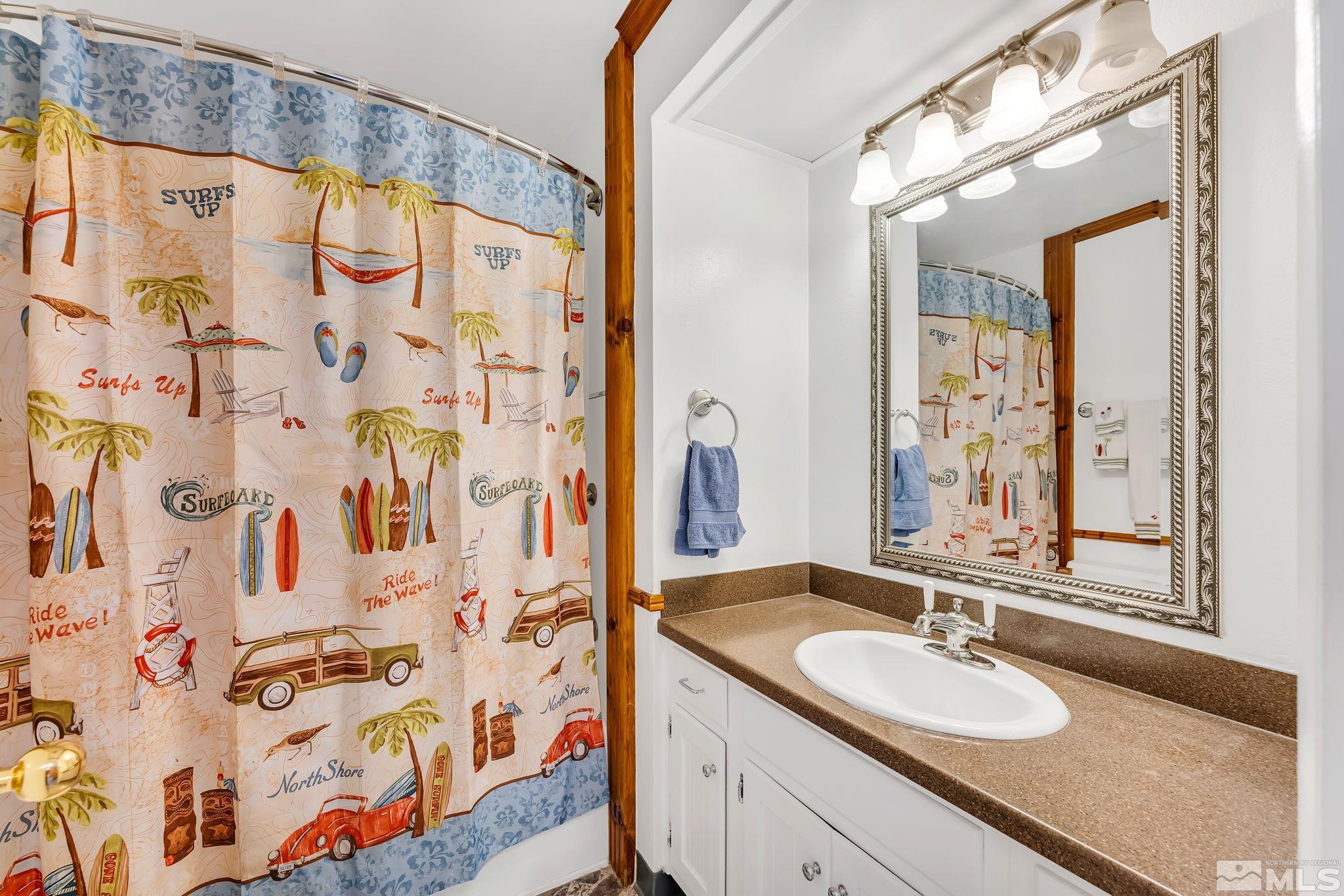 1407 Foster Drive Reno, NV 89509 - Photo 23 of 34 a bathroom with a granite countertop sink a mirror and shower curtain