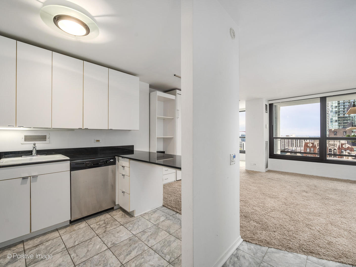 1030 North State Street, Unit 13A Chicago, IL 60610 - Photo 11 of 17 a kitchen with granite countertop white cabinets and white appliances