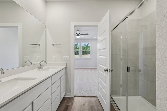 a bathroom with a granite countertop sink a shower and a mirror