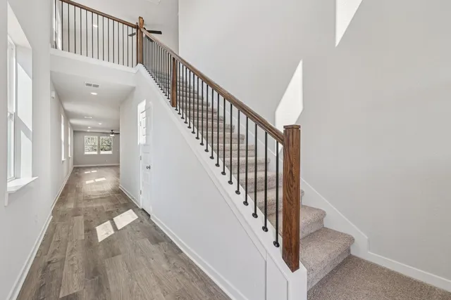 a view of staircase with wooden floor and a rug