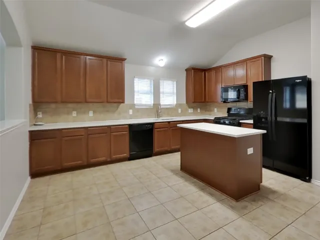 a kitchen with stainless steel appliances granite countertop a stove a sink dishwasher a refrigerator and a microwave oven