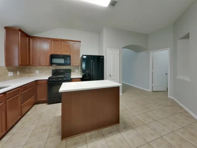 a kitchen with stainless steel appliances a refrigerator and a stove top oven