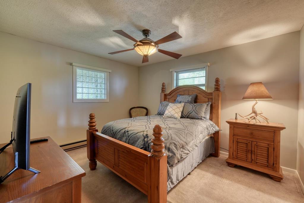 980 Mining Gap Road Young Harris, GA 30582 - Photo 17 of 70 a large bedroom with a bed and a flat tv screen on dresser