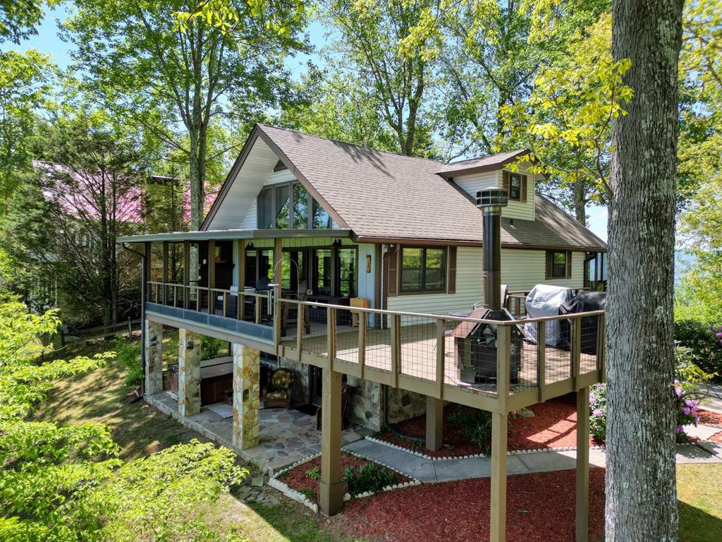 980 Mining Gap Road Young Harris, GA 30582 - Photo 2 of 70 a wooden deck with a table and chairs under an umbrella