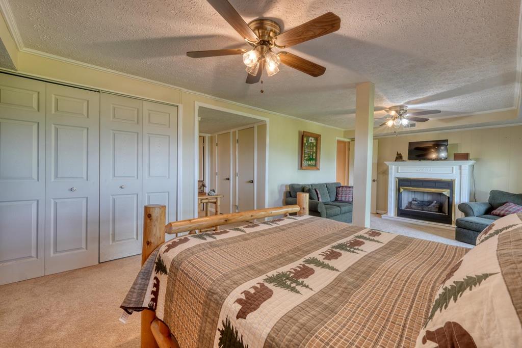 980 Mining Gap Road Young Harris, GA 30582 - Photo 39 of 70 a spacious bedroom with a bed and a fireplace