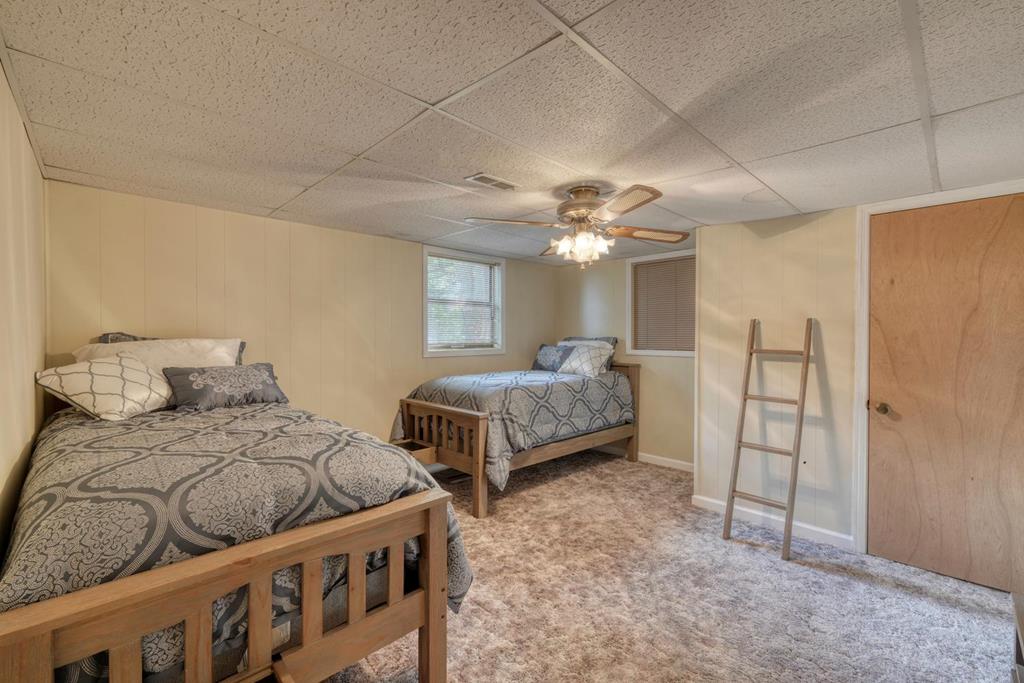 980 Mining Gap Road Young Harris, GA 30582 - Photo 42 of 70 a bedroom with two beds and a chandelier