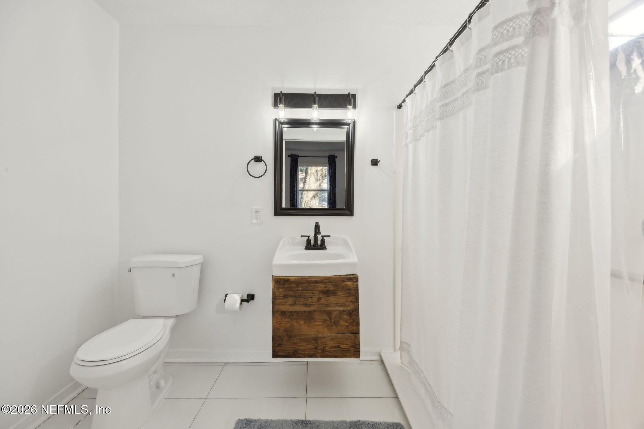 1171 Scotten Road Jacksonville, FL 32205 - Photo 19 of 30 a bathroom with a toilet a sink and mirror