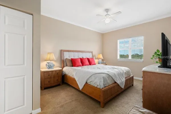 a bedroom with a bed and a flat tv screen on dresser