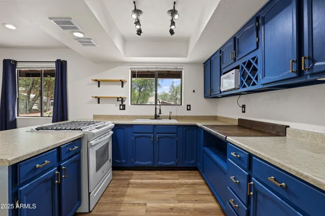 a kitchen with stainless steel appliances granite countertop a sink dishwasher stove and cabinets with wooden floor