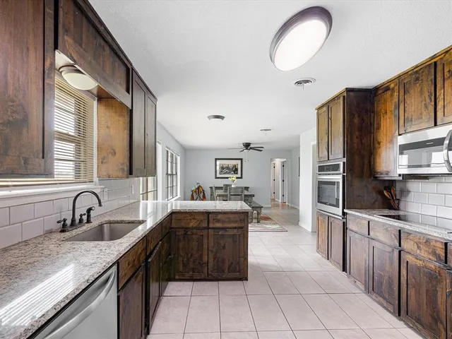 a kitchen with stainless steel appliances a sink stove and cabinets