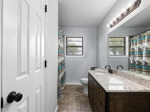 a bathroom with a granite countertop sink a mirror and a shower