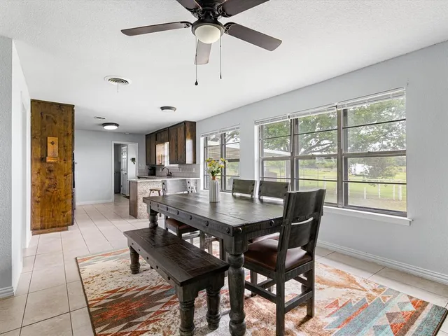 a dining room with furniture a chandelier and wooden floor