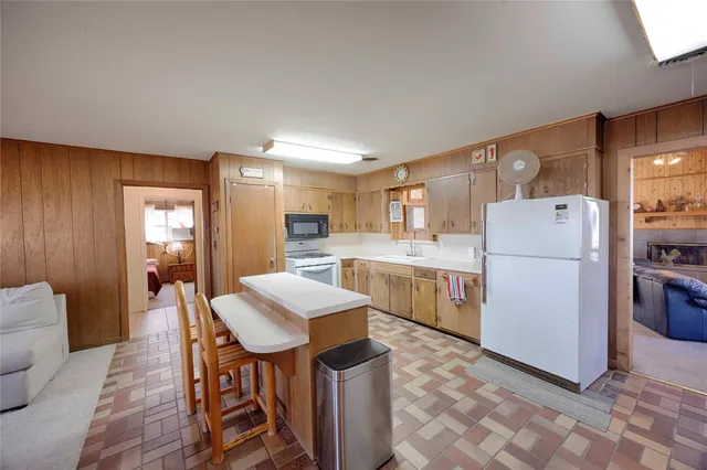 a kitchen with a refrigerator a stove a sink dishwasher with a dining table and chairs