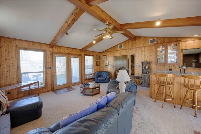 a living room with furniture ceiling fan and a large window