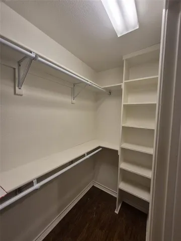 a hallway with walk in closet with empty racks