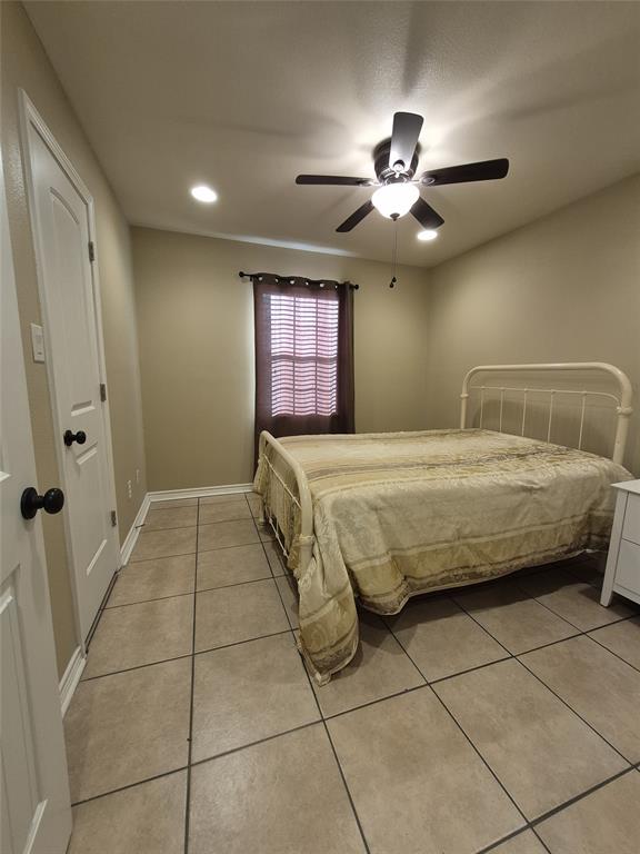 117 Maverick Trail Oak Point, TX 75068 - Photo 8 of 14 a bedroom with a large bed and a ceiling fan