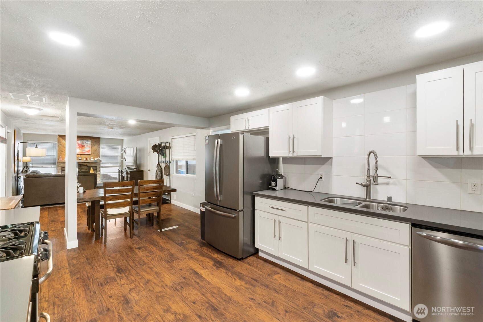 2322 Pamela Place Steilacoom, WA 98388 - Photo 10 of 24 a kitchen with stainless steel appliances a refrigerator a sink dishwasher a stove with white cabinets and wooden floor