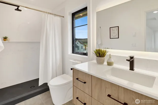 an empty room with wooden floor closet and windows