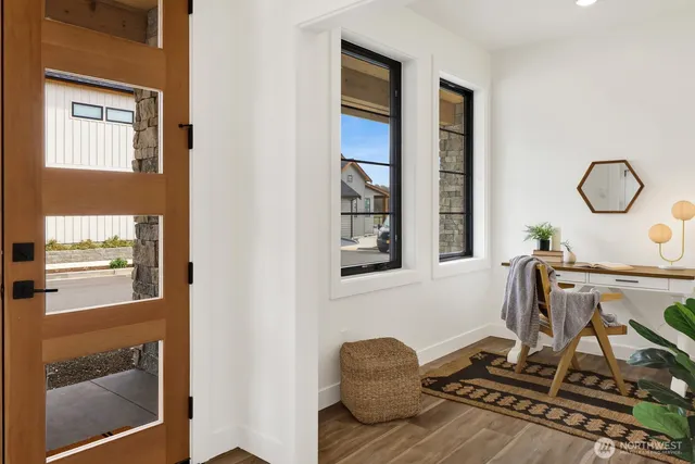 a kitchen with stainless steel appliances granite countertop a stove top oven a sink a refrigerator white cabinets and wooden floor