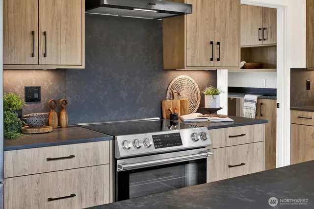 a kitchen with stainless steel appliances granite countertop a refrigerator a sink and a stove