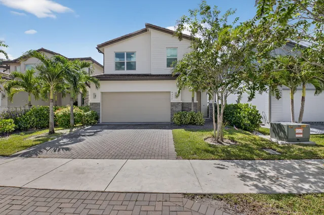 a front view of a house with a yard and a garage