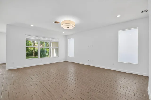 an empty room with wooden floor and window