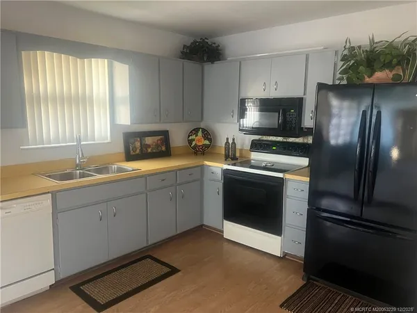 a kitchen with a refrigerator and white cabinets
